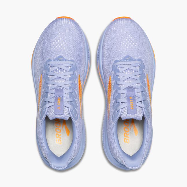 Pair of light blue brooks ghost running shoes with orange accents on a white background