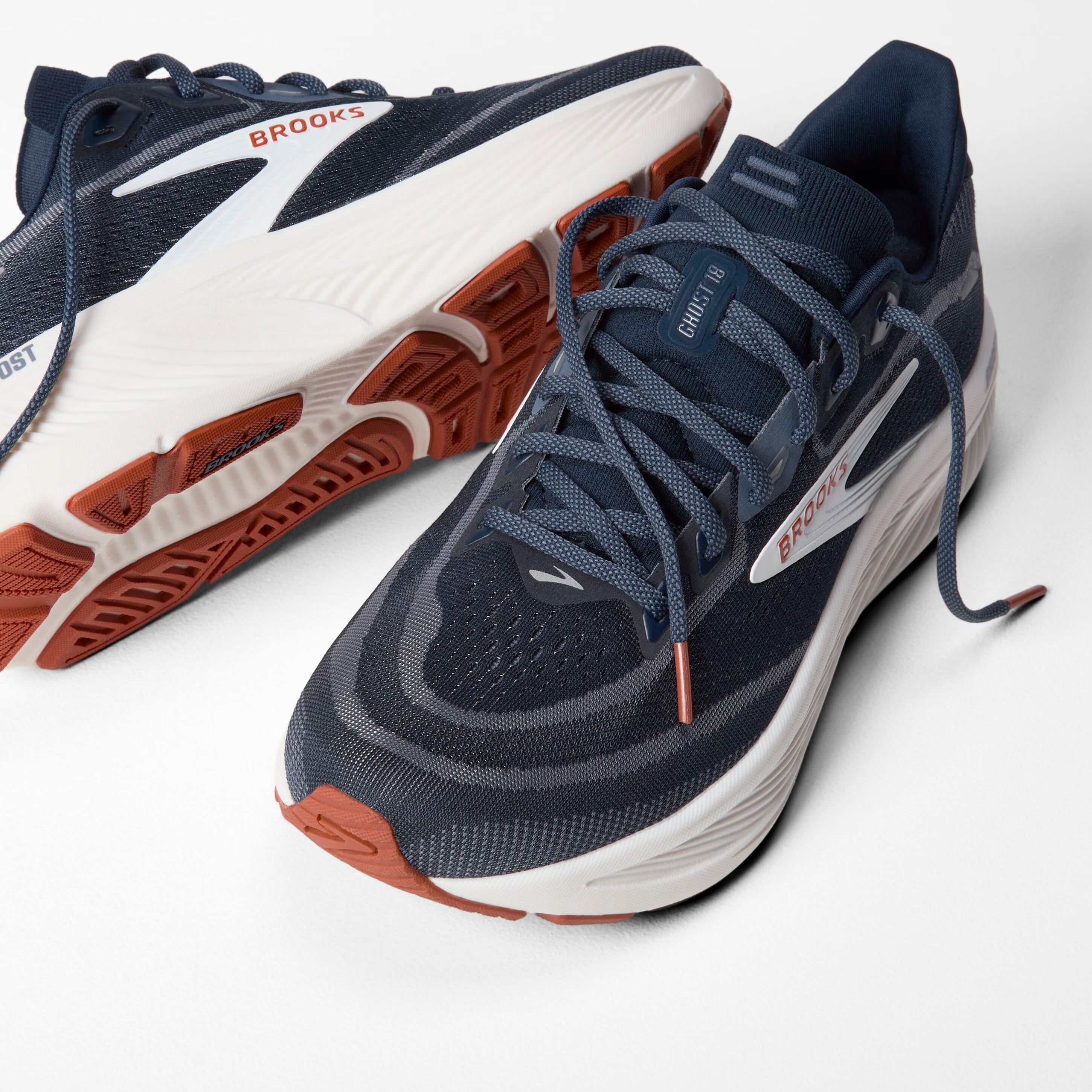 brooks ghost 18, road running and walking shoe for men, soft cushioning and balanced support, navy with white and brick red details, top and side of shoe with laces untied