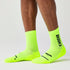 brooks ghost crew, maximum cushioning long run socks, neon green with black logo, person wear socks side profile 