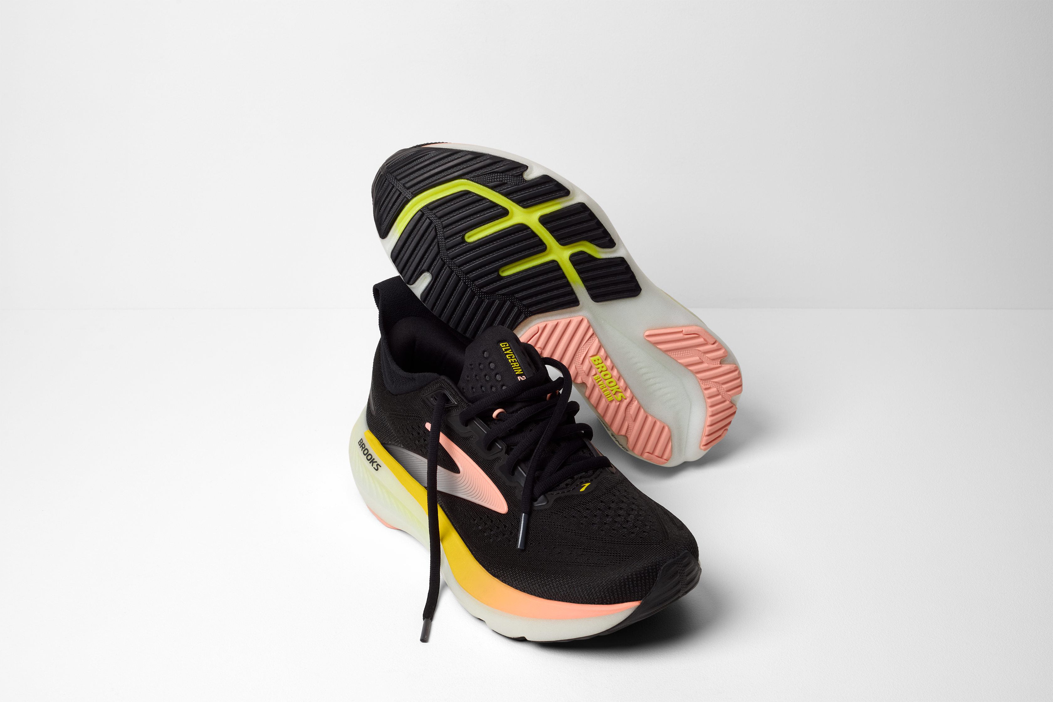 brooks glycerin 23 women, maximum cushioned road running and walking shoe, black with yellow and peach details, pair of shoes with laces untied and one overturned