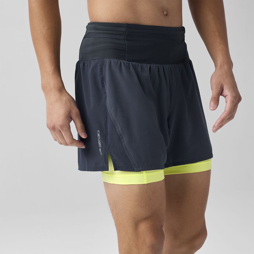 Man wearing Brooks High Point 2in1 trail shorts for men black and yellow colour