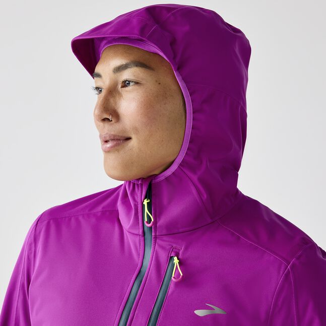 Woman wearing brooks high point waterproof running jacket purple, dark fuchsia 