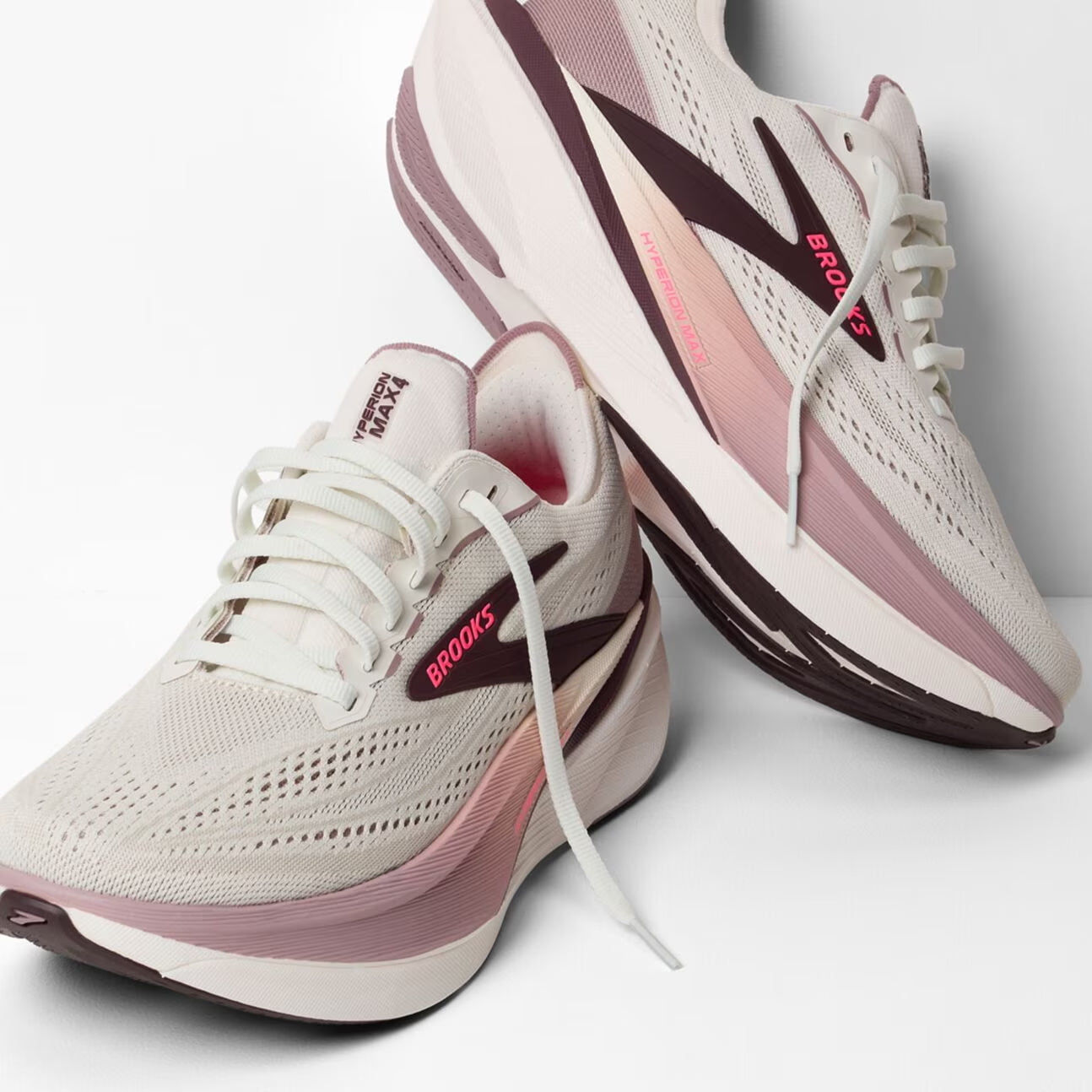 brooks hyperion max 4 womens, high cushion stacked nylon plated training long distance running shoe, white with purple details, shoe stacked ontop of of one another with untied laces
