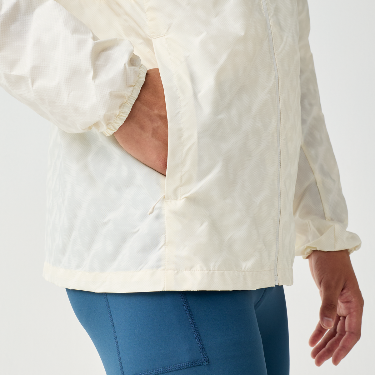 Close up of man putting his hand into the pocket of the Brooks Canopy Reflective Run Jacket, white colour, reflective details