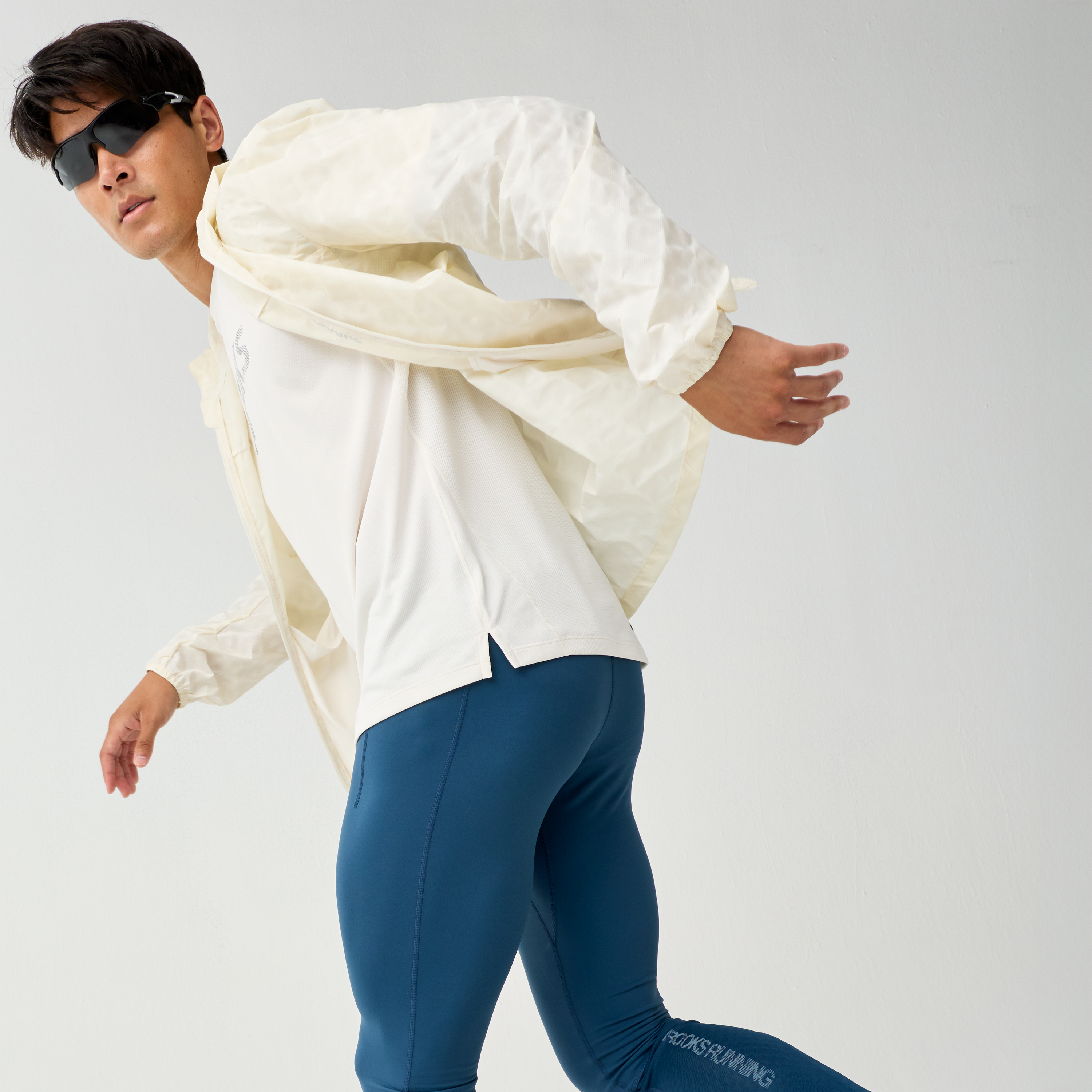 Man wearing Brooks Canopy Reflective Run Jacket, white colour, reflective details, showing the man moving in the jacket