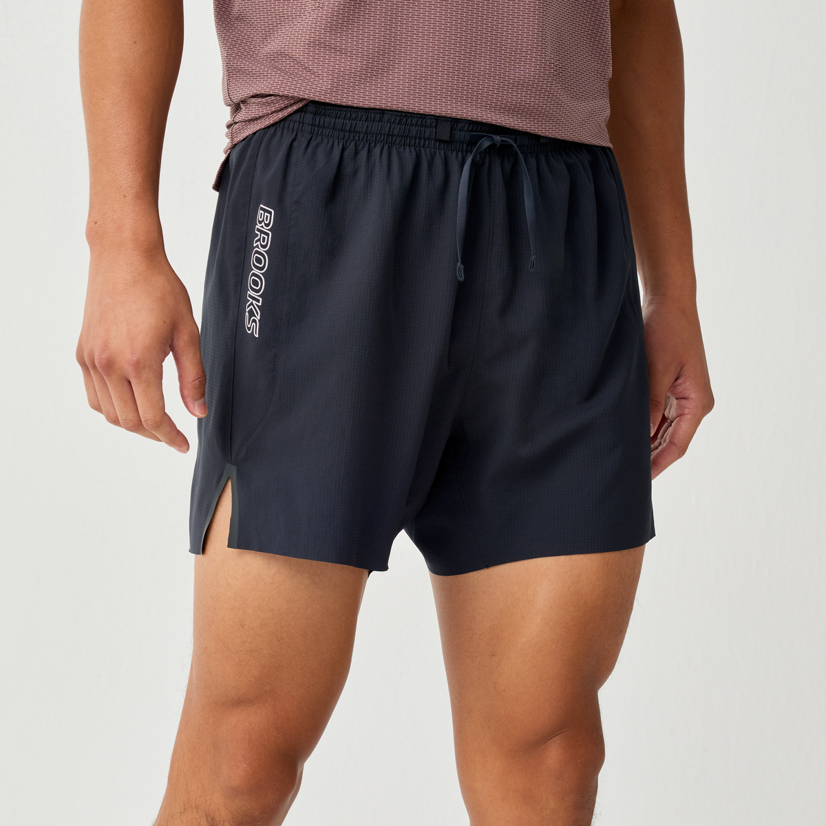 brooks cascadia short for men, running short with pocket storage belt, black colour with white brooks logo, waist down of man wearing short