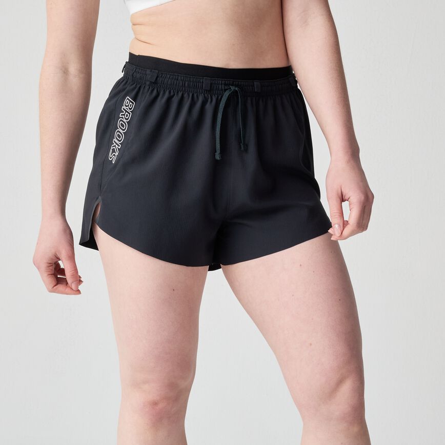 woman wearing brooks cascadia running short, lightweight women's trail-running shorts, black with white logo