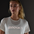 brooks womens dash reflective short sleeve, super lightweight and breathable running top, white colour with silver reflective logo, woman wearing tshirt in dark with reflective logo lighting up