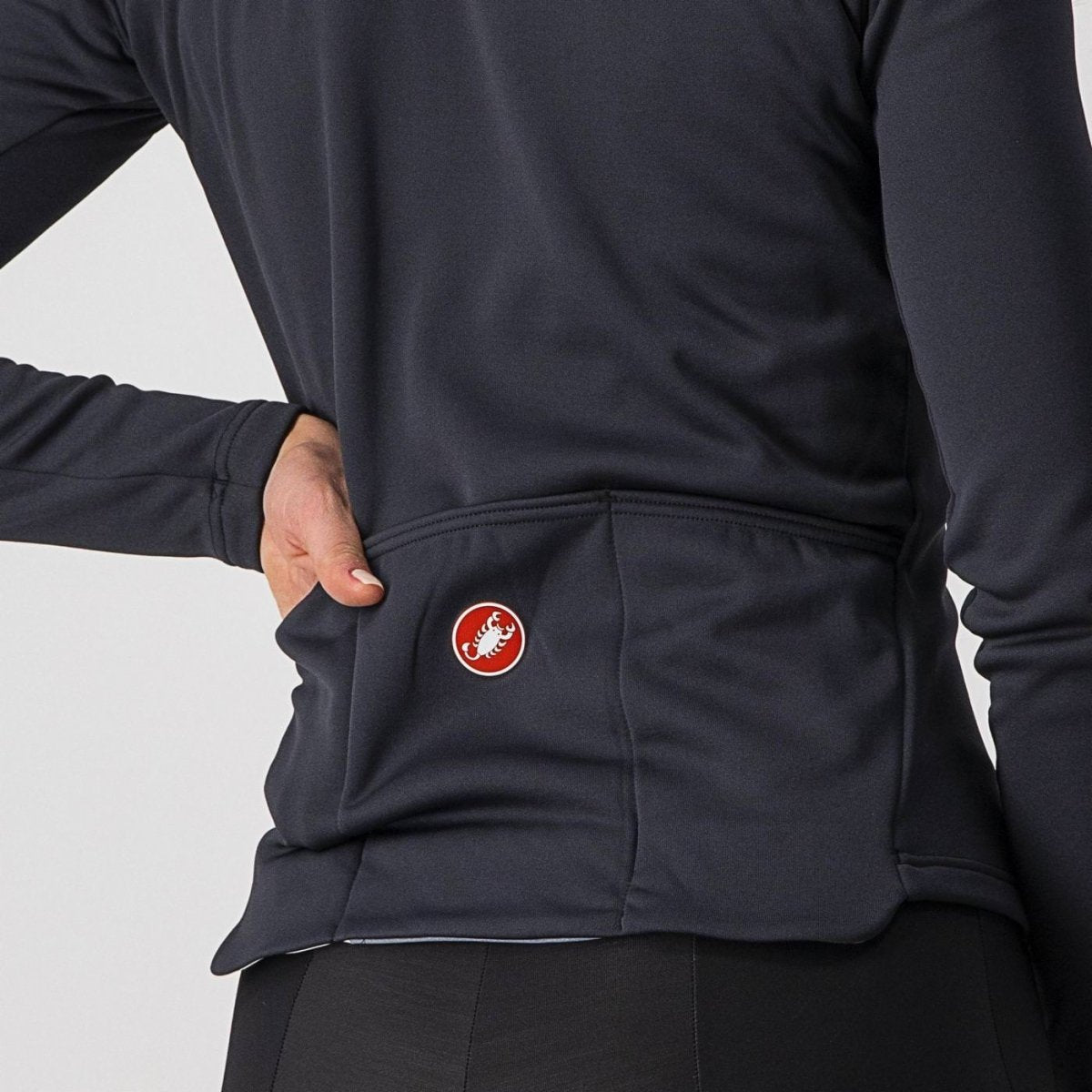 woman wearing light black castelli sinergia thermal cycling jacket, showing back drop pocket