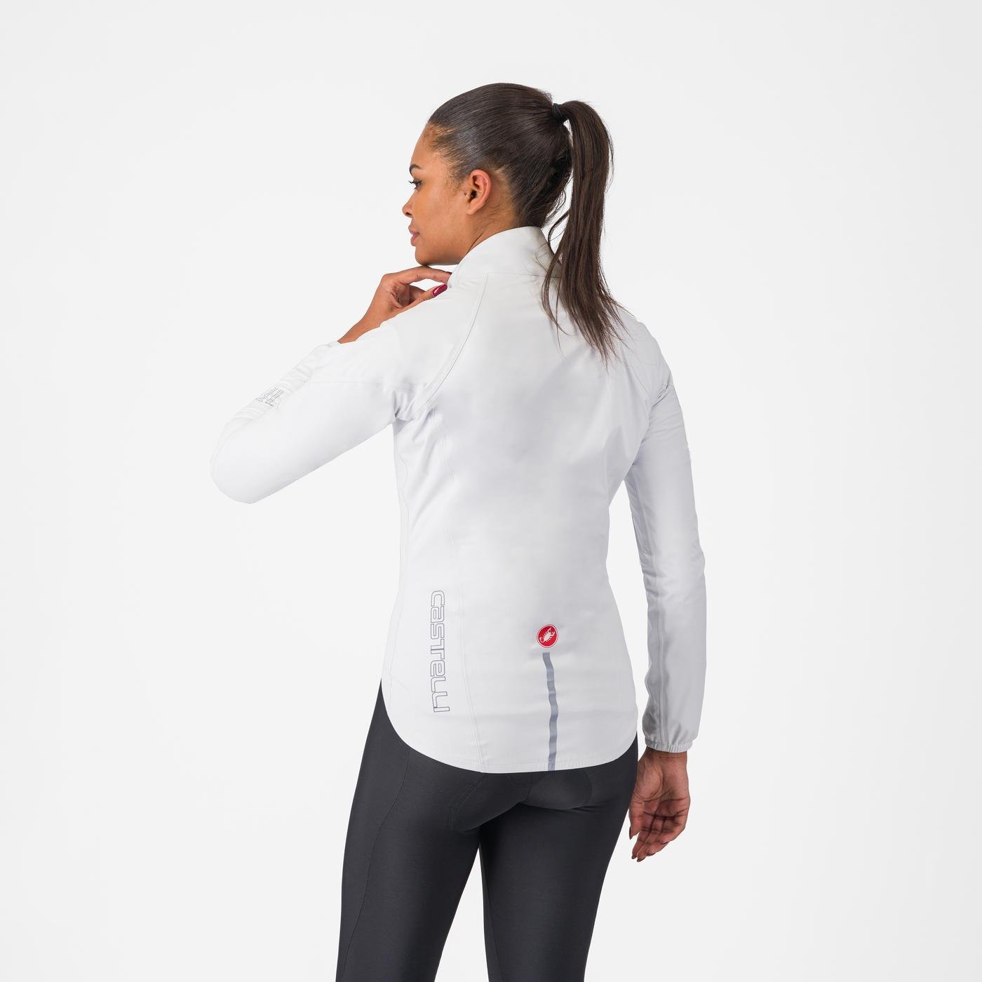 woman wearing castelli emergency 3 waterproof cycling jacket in white, showing back