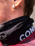 Close-up of a person wearing a black compress port neck warmer with a brand logo.