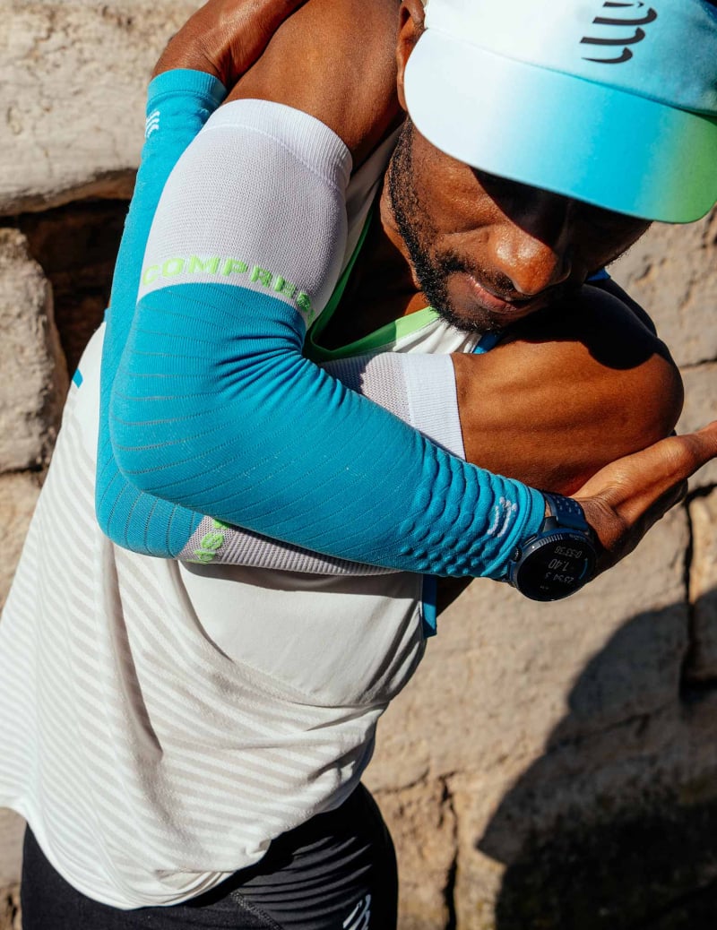 man training in compressport armforce armsleeves in blue and white