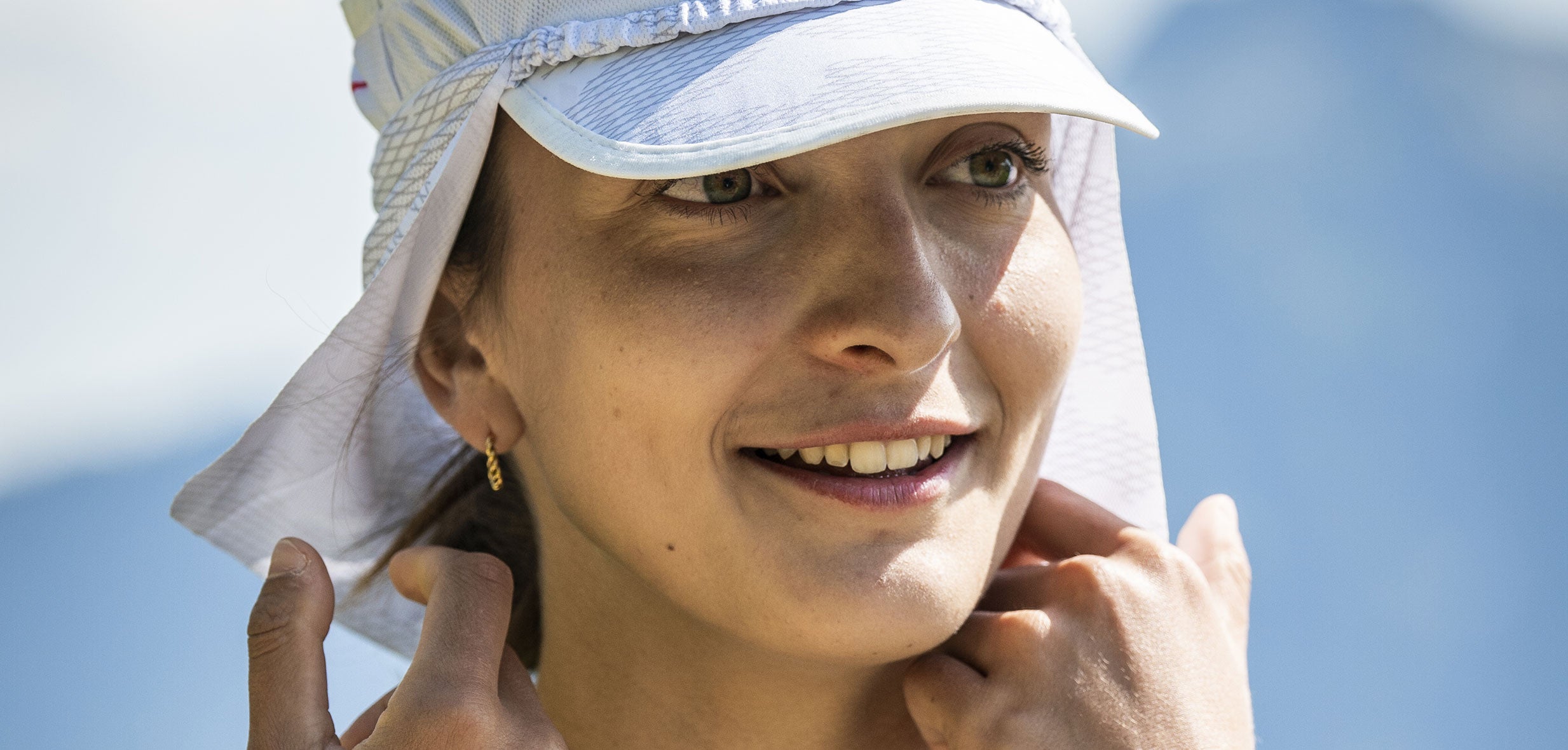 compressport ice cap sun shape, woman wearing white running hat with neck protection
