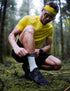 compressport pro racing trail socks, quarter length compression trail running sock, light turquoise with dark turquoise band and purple detail, man adjusting compressport sock