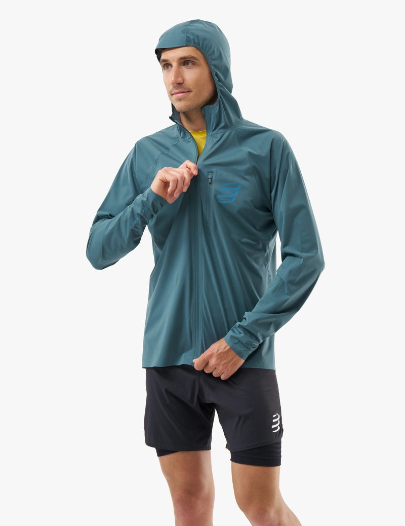 compressport tempest waterproof jacket, breathable and waterproof running jacket, deep aqua blue colour, front of jacket male  model
