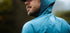compressport tempest waterproof jacket, breathable and waterproof running jacket, deep aqua blue colour, close up of jacket material with water droplets