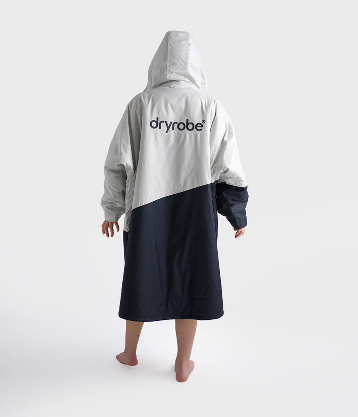 dryrobe long sleeve changing robe for all gender, light grey and navy colour with lime green interior, woman wearing dryrobe, view of back