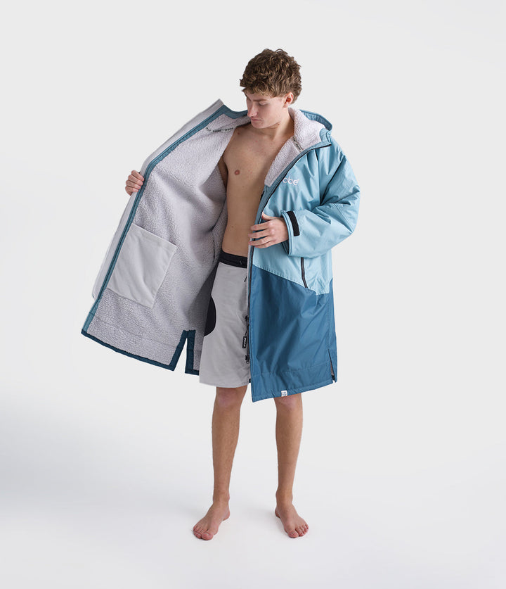 dryrobe long sleeve changing robe for all gender, light blue colour with dark blue contrast, man wearing dryrobe zipped open, displaying light grey interior
