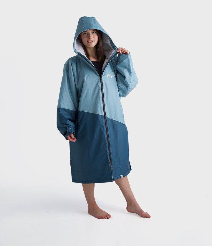 dryrobe long sleeve changing robe for all gender, light blue colour with dark blue contrast, woman wearing dryrobe zipped up