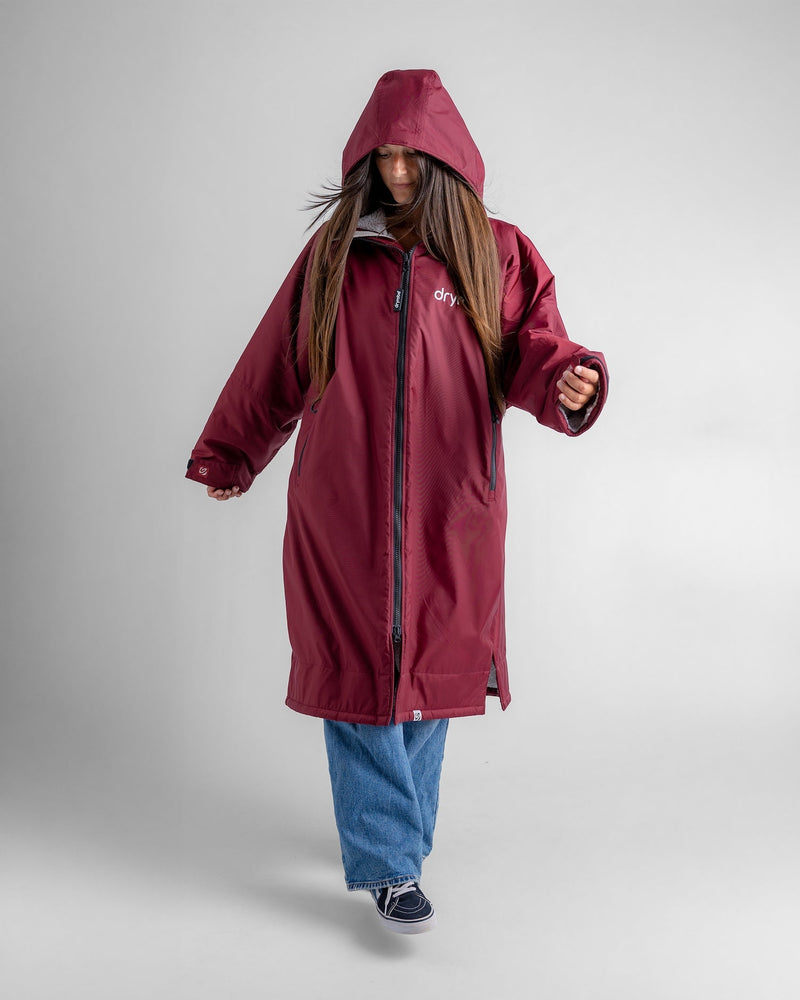 woman wearing dryrobe changing robe in new burgundy colour with hood up