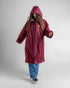 woman wearing dryrobe changing robe in new burgundy colour with hood up