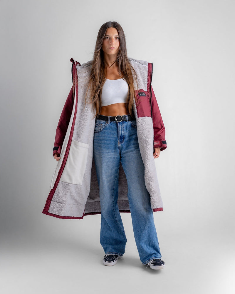 woman wearing dryrobe changing robe in new burgundy colour, showing internal pockets and fleece lining