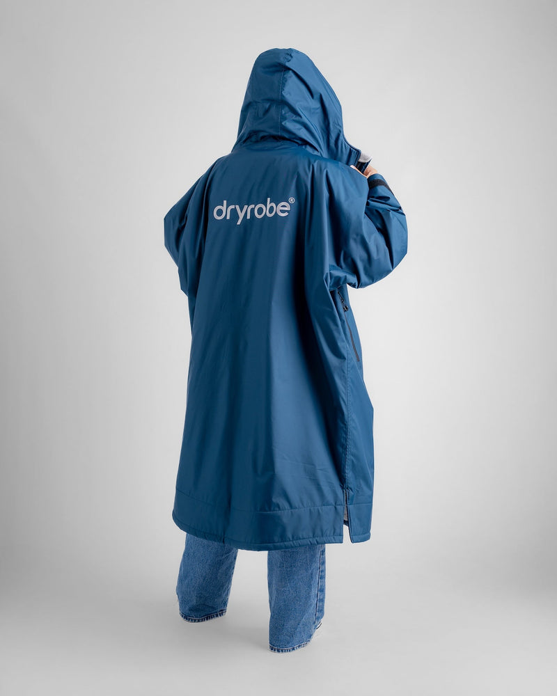 woman wearing dryrobe long sleeve changing robe showing hood up and large logo on the back