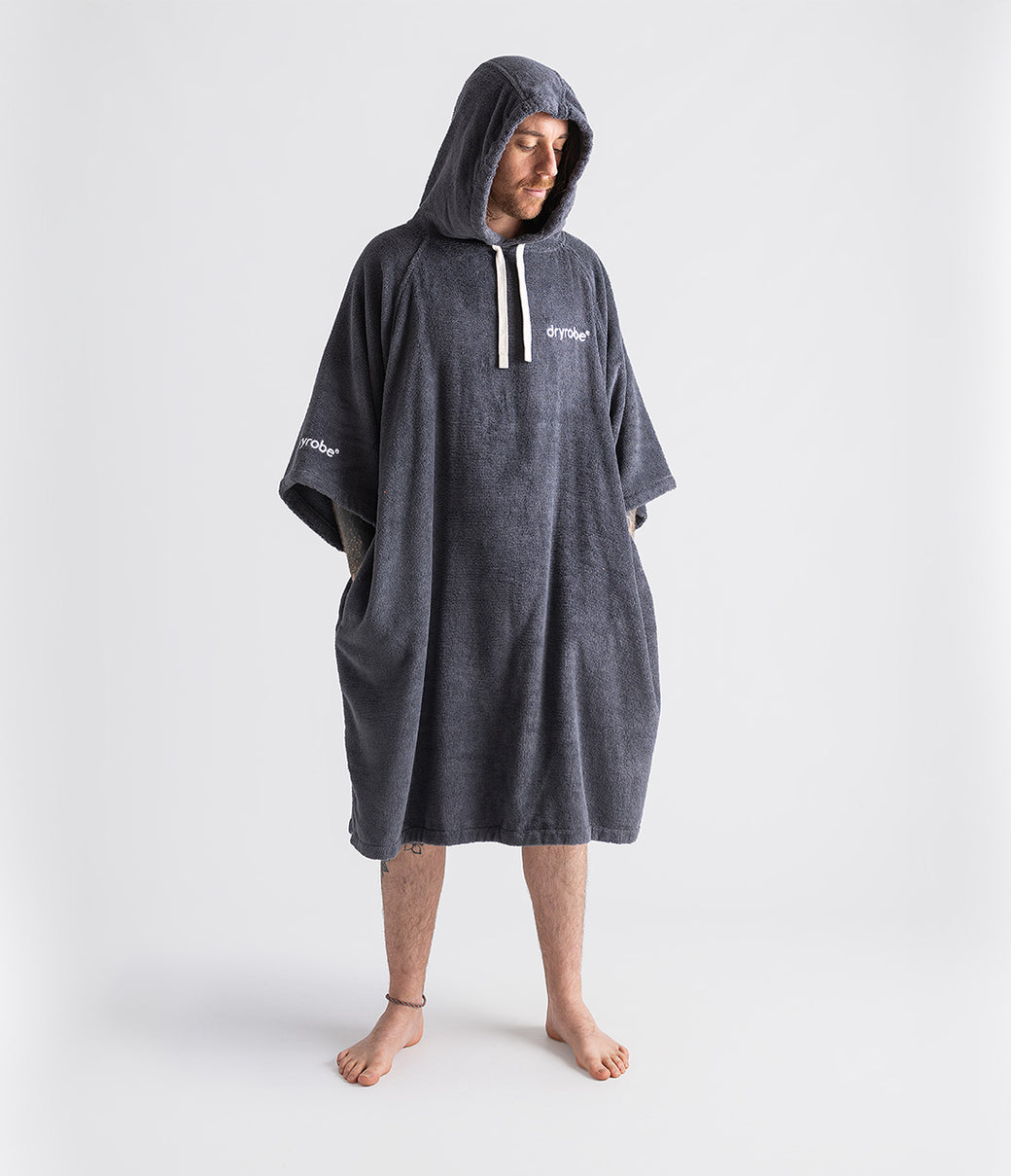 dryrobe organic cotton changing robe for swimming, soft and absorbent towelling robe for all gender, dark grey colour, man wearing dryrobe towel on a white background