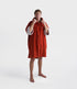 dryrobe towel robe for men and women, full zip towel robe for after swimming, dark orange colour with white sleeve caps, man wearing orange zipped up dryrobe with hood up