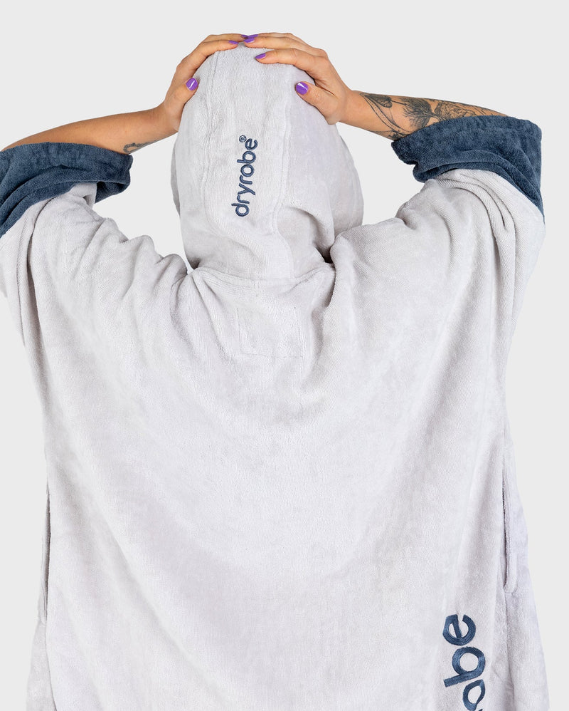 dryrobe towel robe for men and women, full zip towel robe for after swimming, light grey white colour with grey sleeve caps, dryrobe with hood up from behind