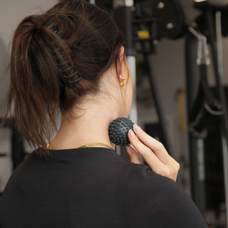 woman using fitness mad latex free pinpoint trigger ball on her neck