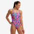 funkita womens single strap swim suit, one peice swim suit with thing strap and open back, pink with rockets and rainbow pattern with purple strap, woman wearing swimsuit on white background