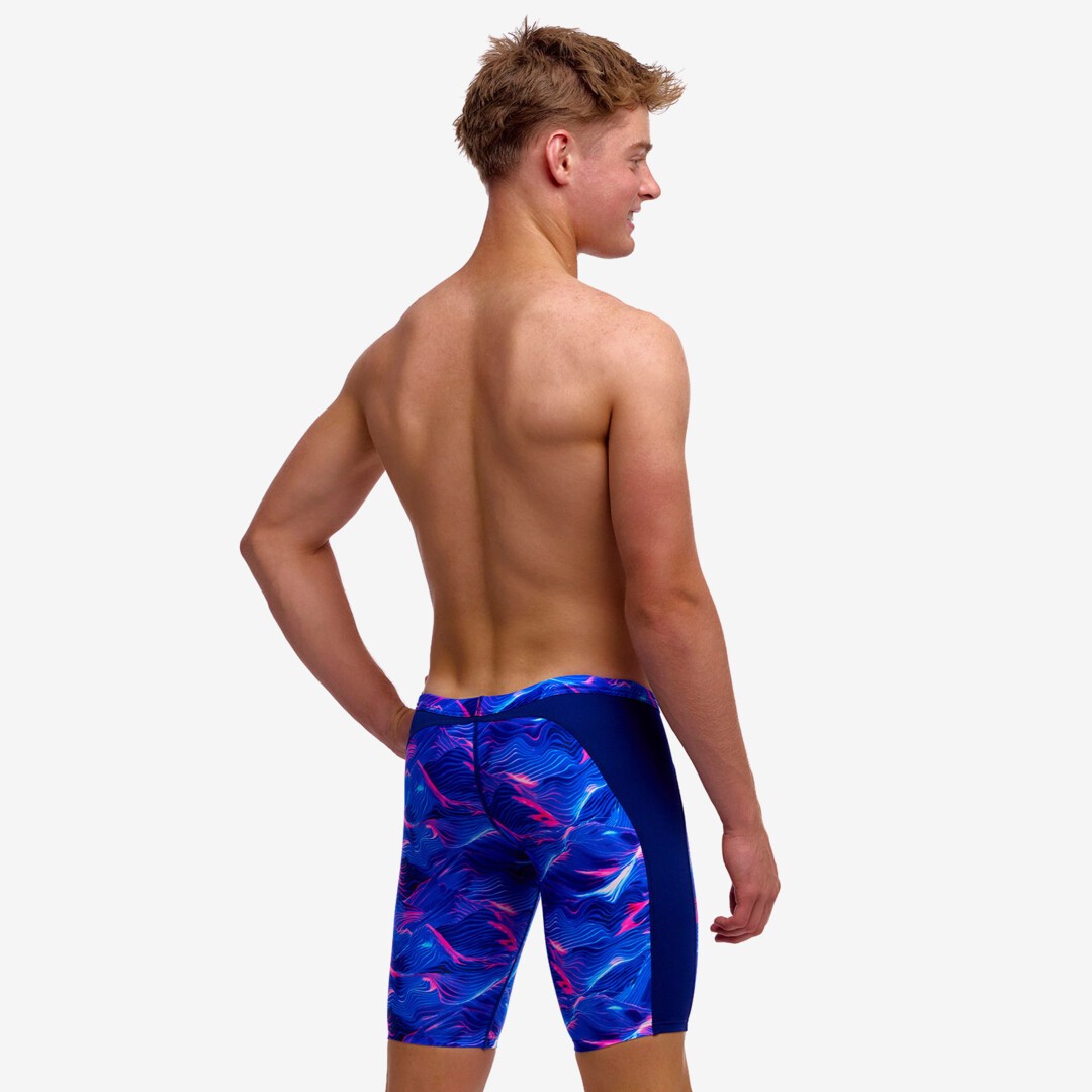boy wearing funky trunks swim jammers in rising tide pattern, showing back