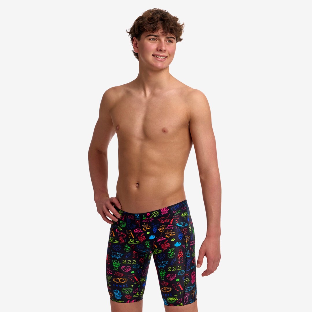 funky trunks boys jammers, boys swimming trunks, black with rainbow pattern, boy wearing swimming bottoms on white background