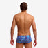 man wearing funky trunks classic trunks in blue bits pattern, showing back
