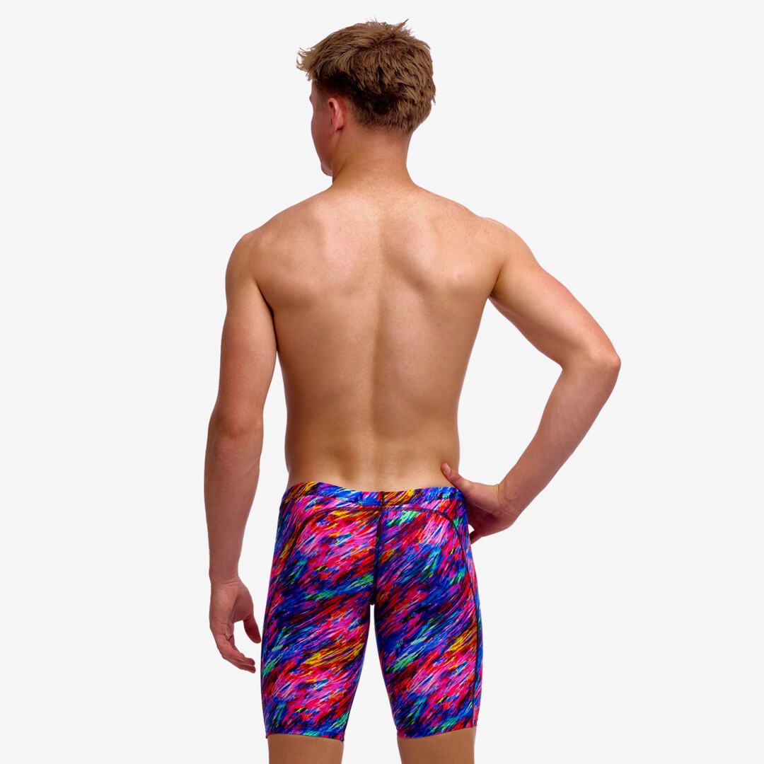 Boy wearing funky trunks jammer in big bang pattern, showing back