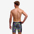 Boy wearing funky trunks jammer in bits of peace pattern, showing back