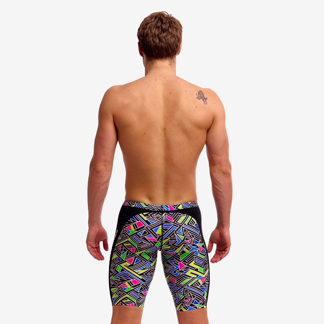 man wearing funky trunks jammer in bits of peace pattern, showing back