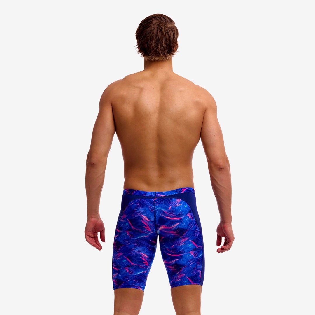 man wearing funky trunks jammer in rising tide pattern, showing back