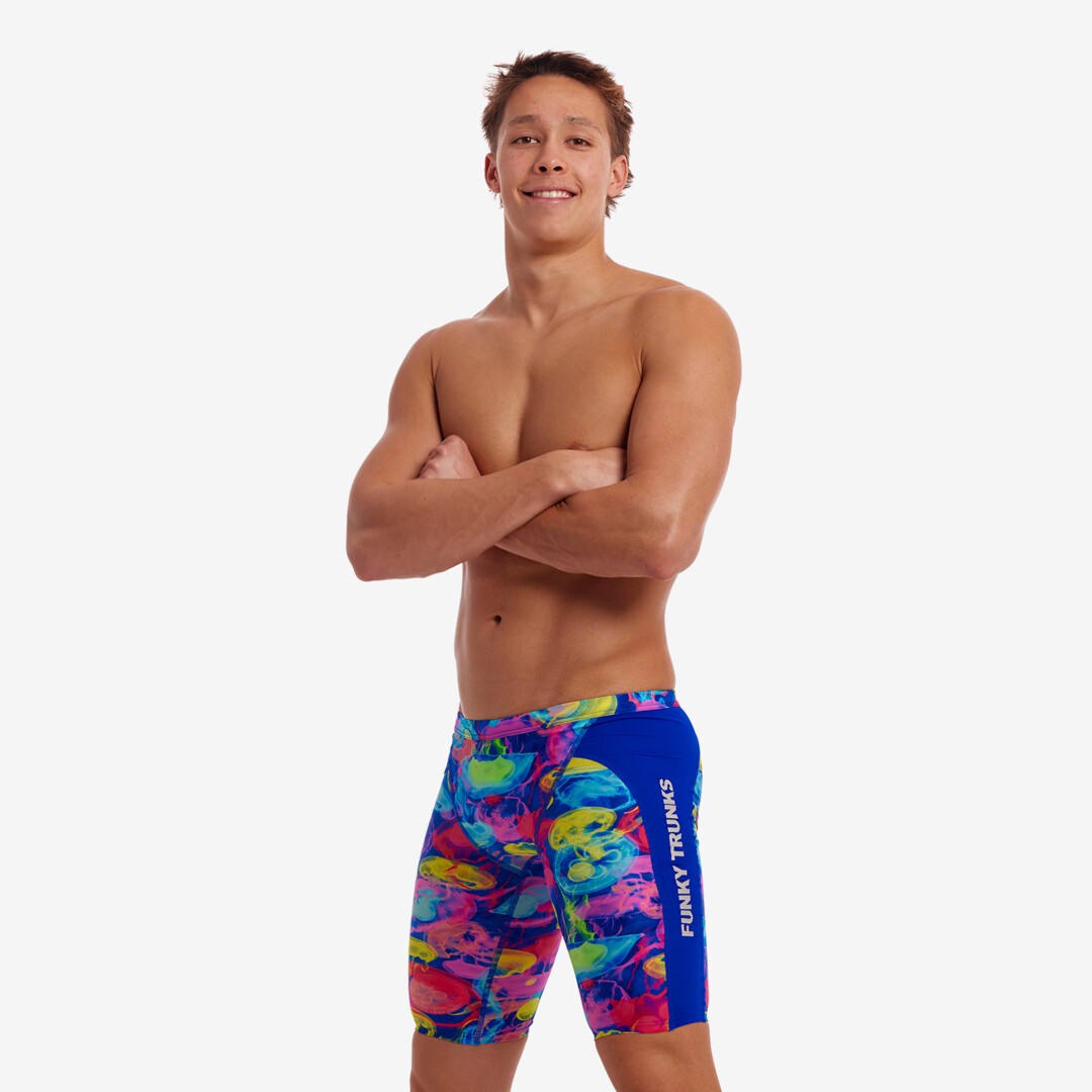 Man wearing colorful swim shorts with 'Funky Trunks' branding on a white background