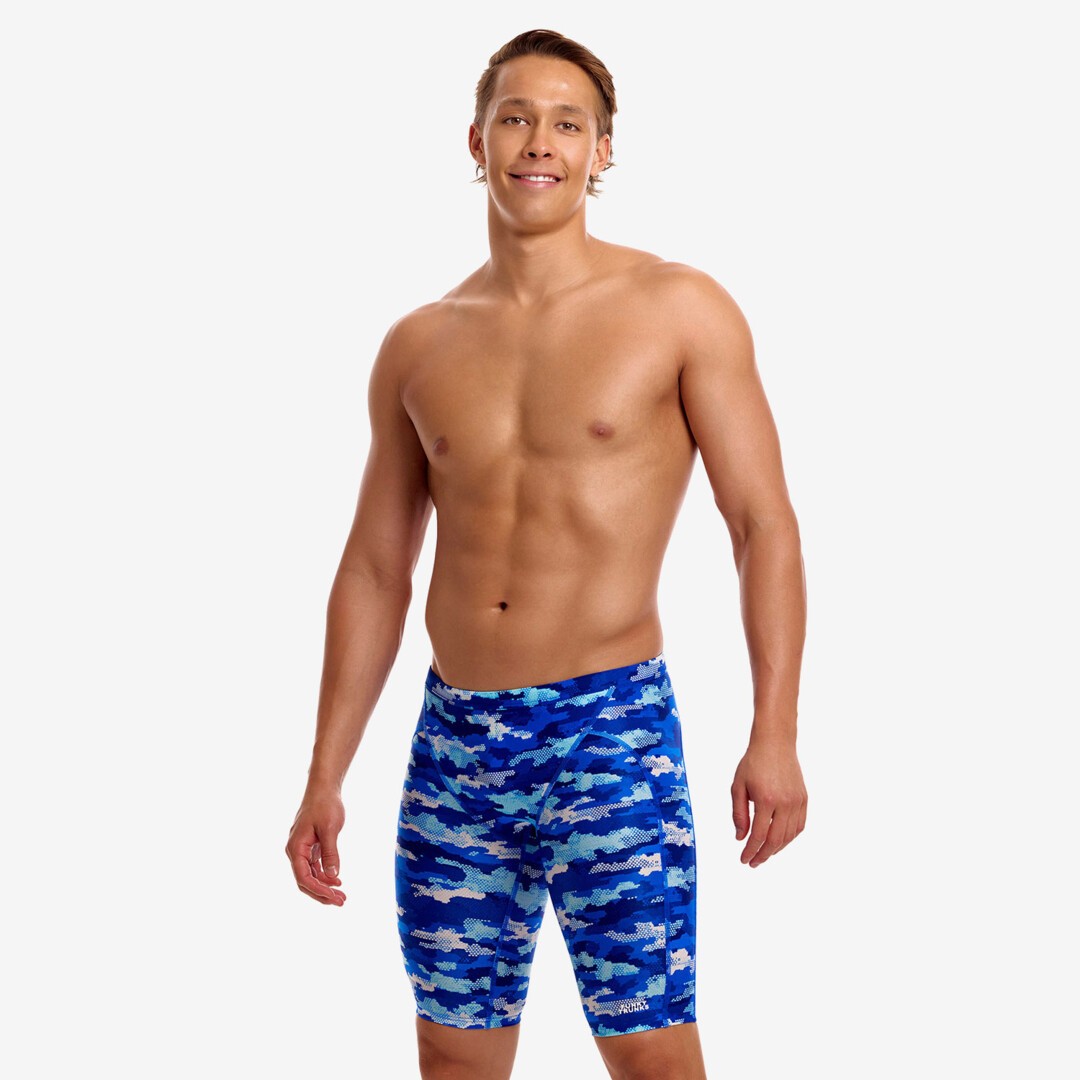 funky trunks jammers, mens tight swimming bottoms, blue camo colour, man standing in swim shorts with white background