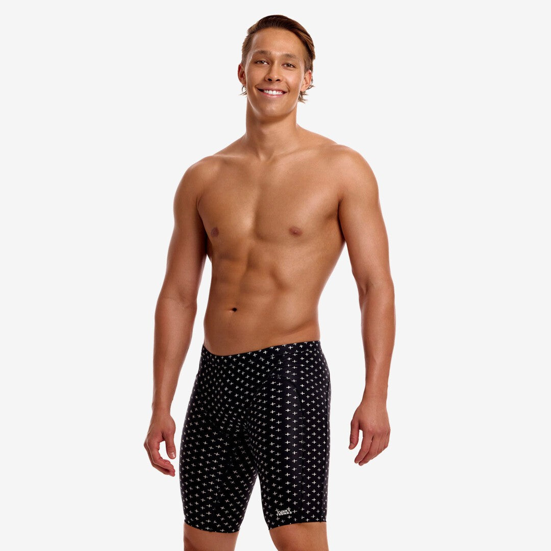 funky trunks mens jammers, tight swim shorts, black with small white pattern, man wearing swim bottoms on white background 