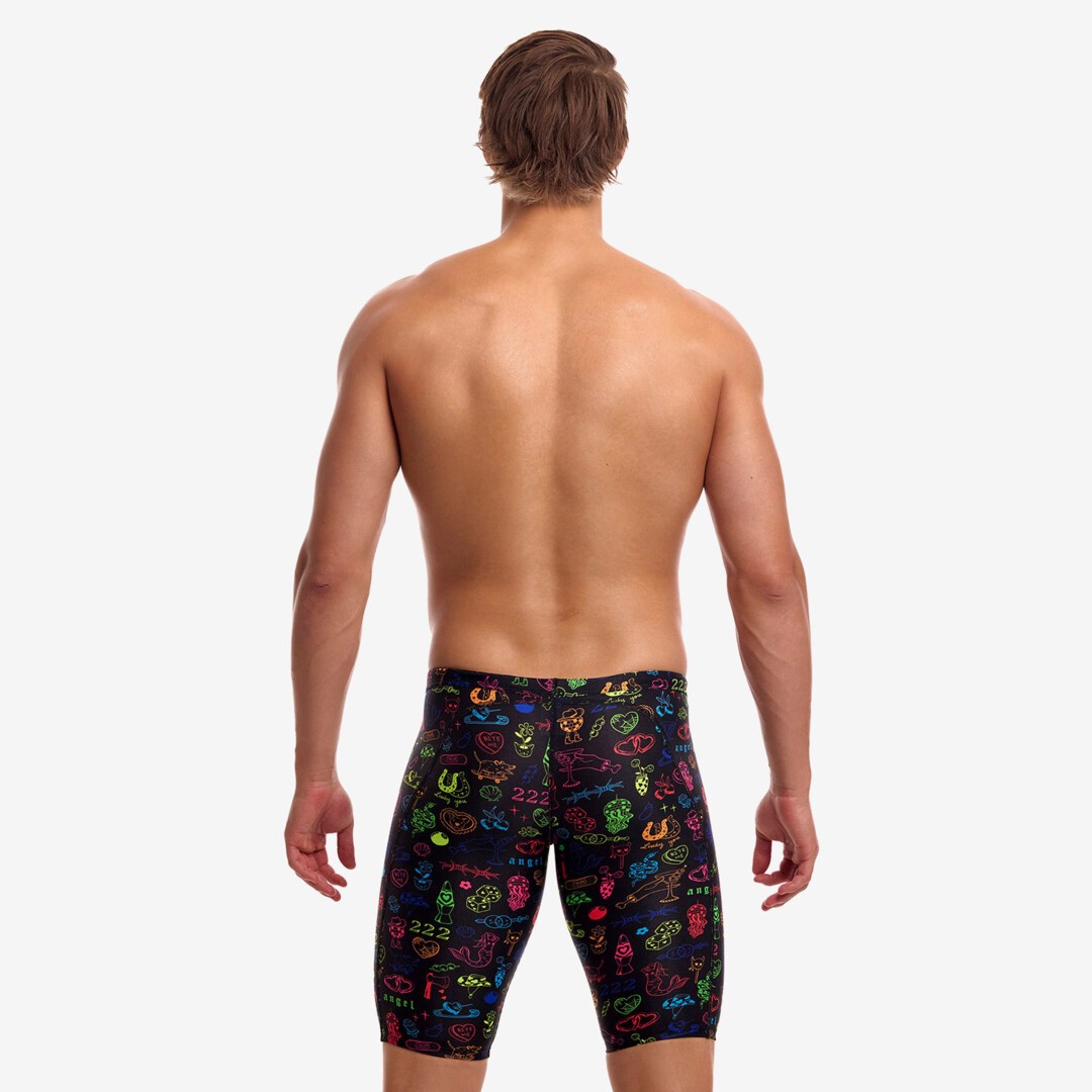 funky trunks jammers, mens tight swimming bottoms, black colour with small rainbow pattern, back of man standing in swim shorts with white background