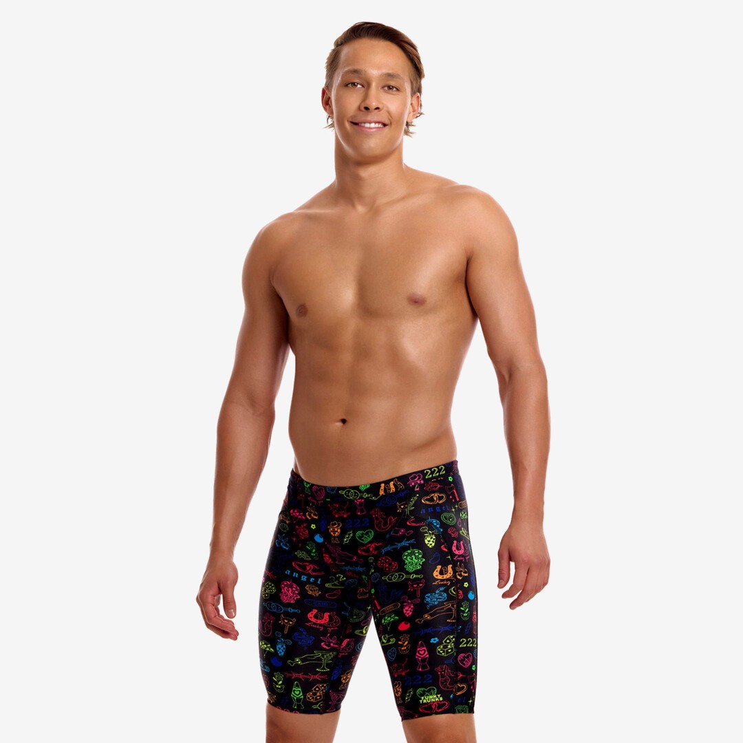 funky trunks mens jammers, tight swim shorts, black with rainbow doodle pattern, man wearing swim bottoms on white background 