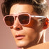 man wearing goodr glasses, threaten me with a good time, pink with brown lenses