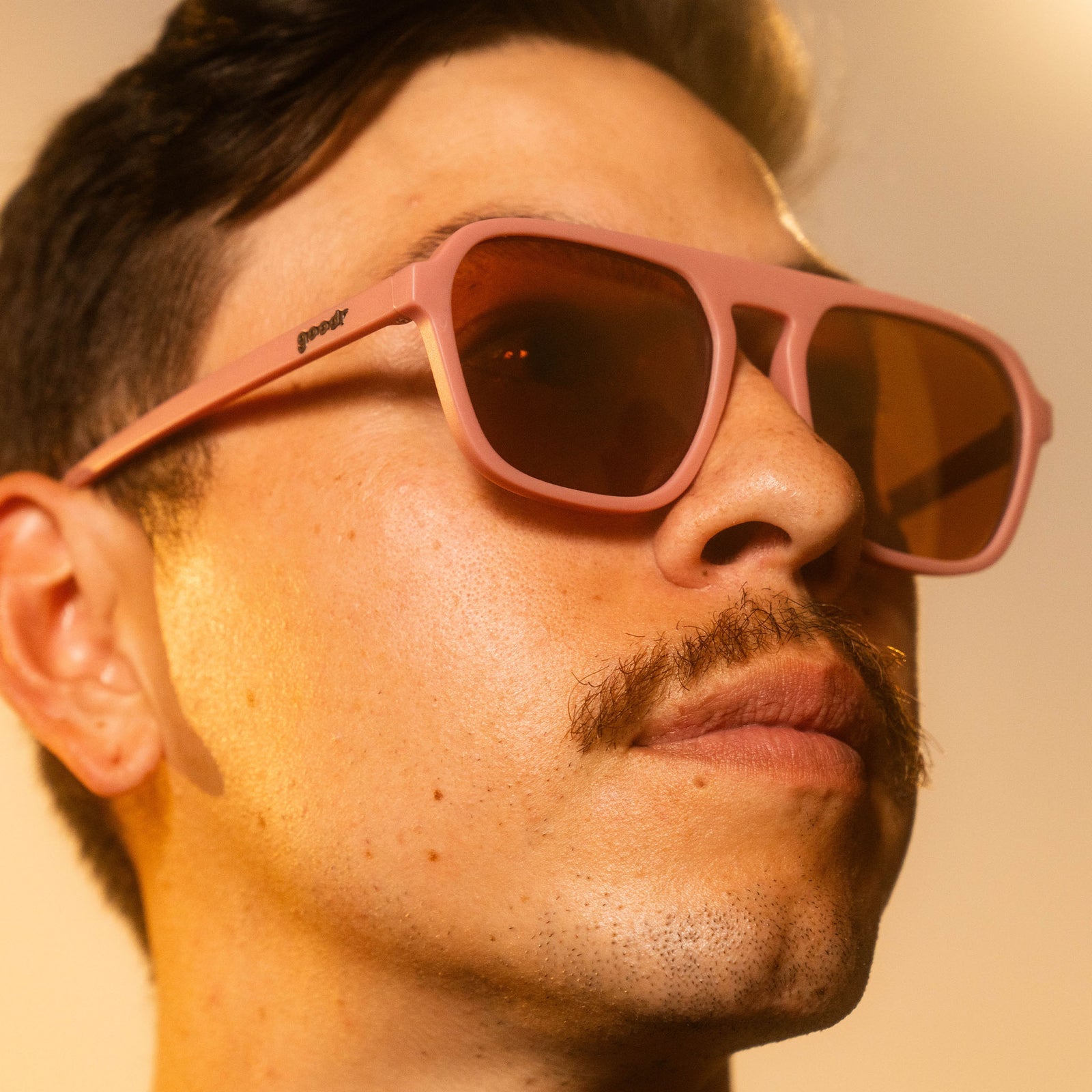 man wearing goodr glasses, threaten me with a good time, pink with brown lenses