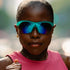 goodr sonic g wrap sunglasses for running with frame vents, teal frame with mirrored reflective lenses, woman wearing sunglasses while running