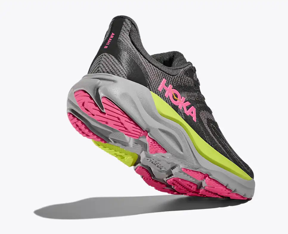 hoka arahi 8 for women, lightweight cushioned support shoe for overpronation when running, dark grey colour with pink details and lime green and grey sole, lifted heel of shoe showing sole