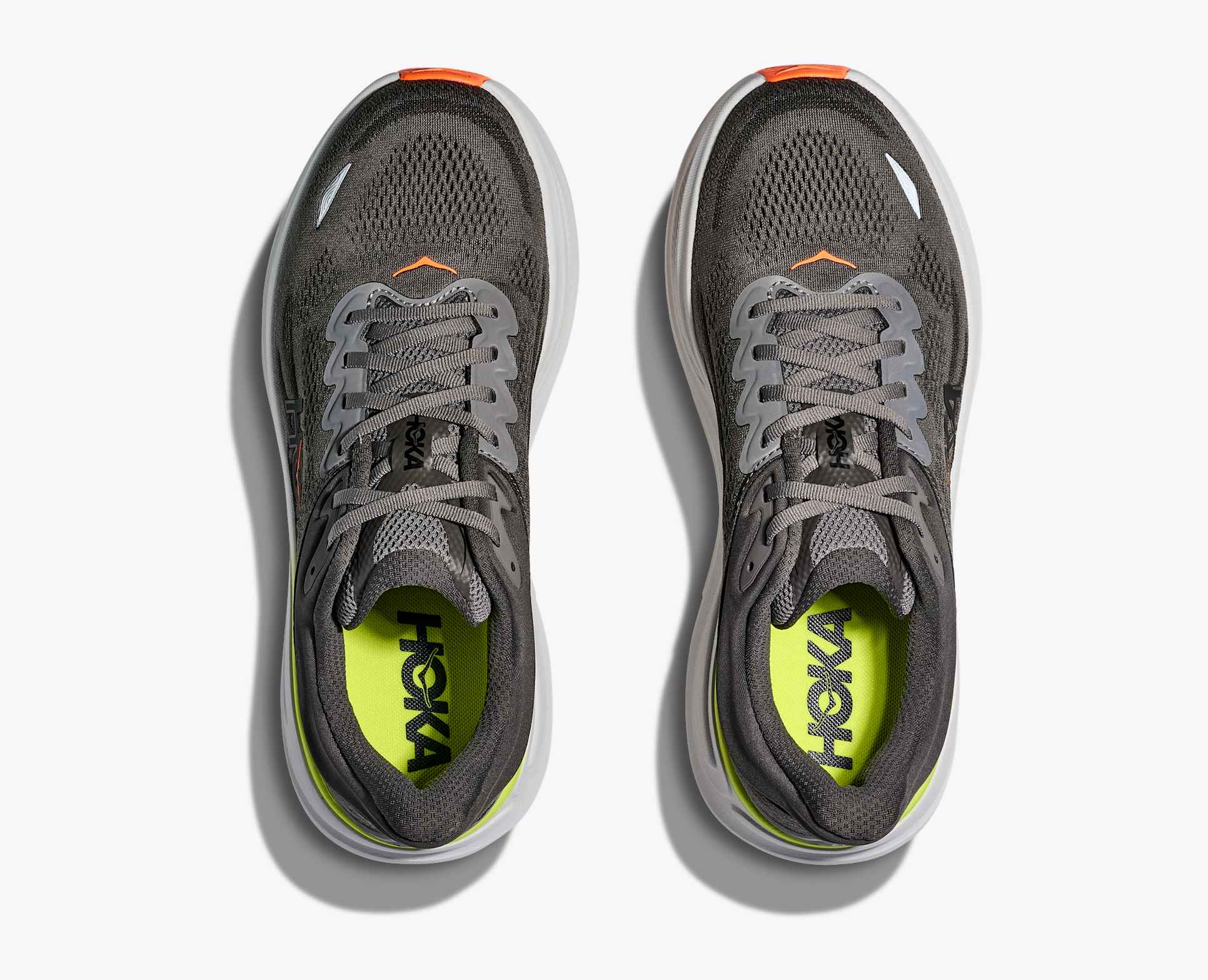 Pair of dark gray hoka bondi 9 running shoe with orange and lime green accents looking down