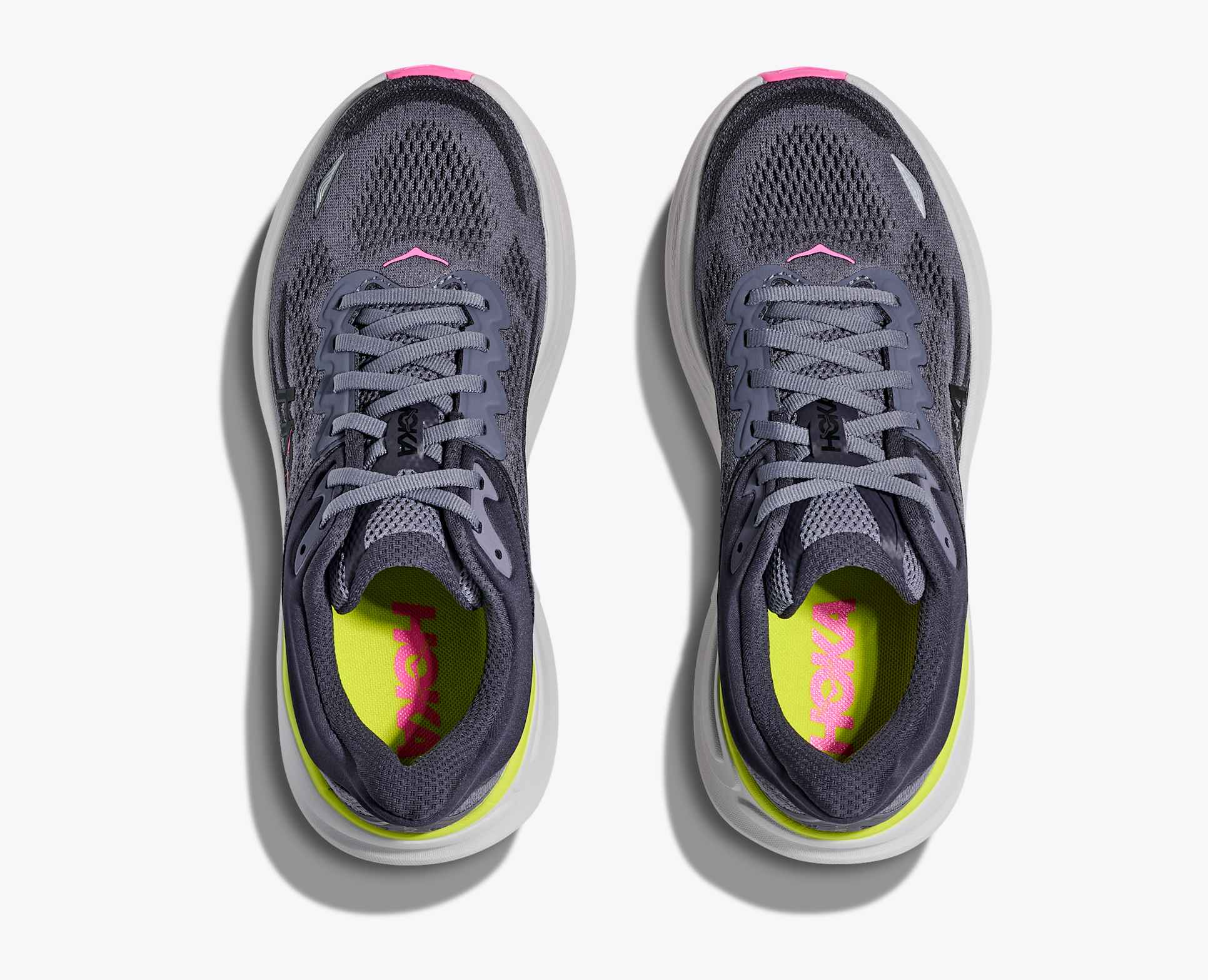 Pair of grey hoka bondi running shoes with pink and green accents view from above